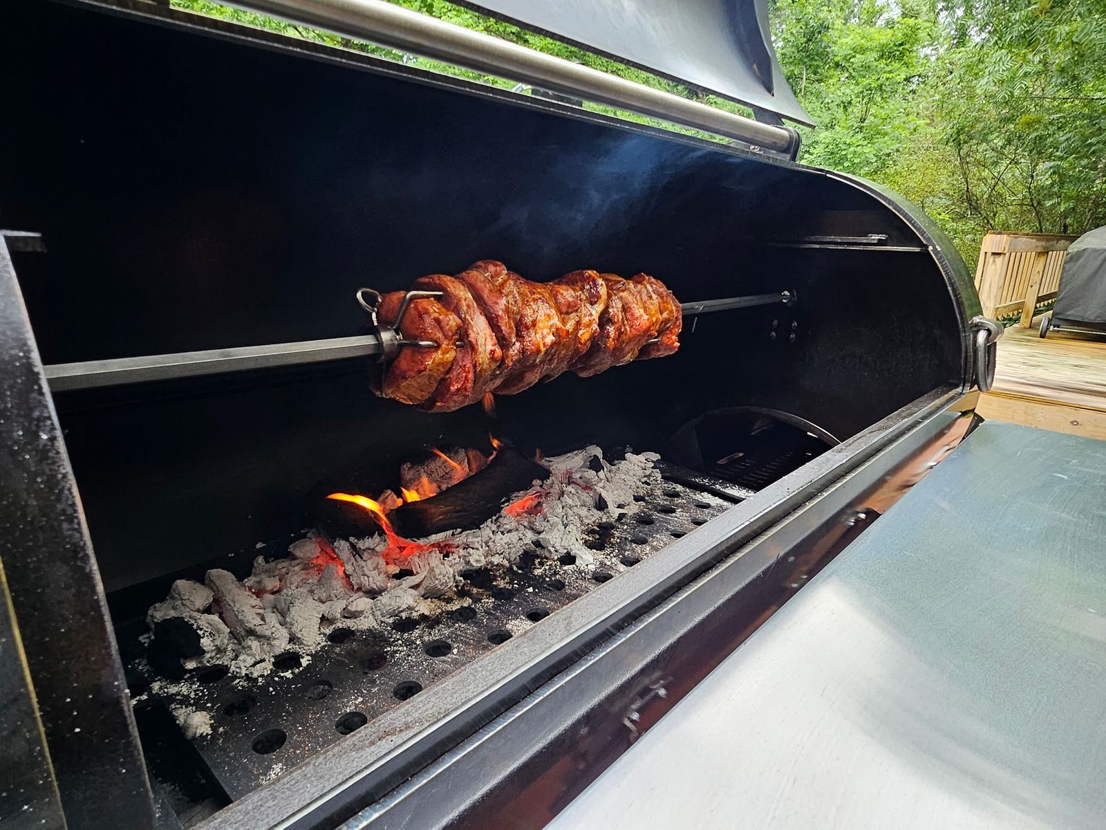 Rotisserie roast turning over live coals